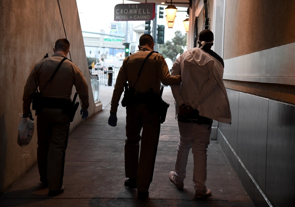 LAS VEGAS, NEVADA - MARCH 19:  Las Vegas Metropolitan Police Department officers take a man into custody on Flamingo Road outside The Cromwell Las Vegas as parts of the Las Vegas Strip go dark as a result of the statewide shutdown due to the coronavirus continuing to spread across the United States on March 19, 2020 in Las Vegas, Nevada. On Tuesday, Nevada Gov. Steve Sisolak announced a statewide closure of all nonessential businesses, including all hotel-casinos on the Strip, for at least 30 days to help combat the spread of the virus. The World Health Organization declared the coronavirus (COVID-19) a global pandemic on March 11th.