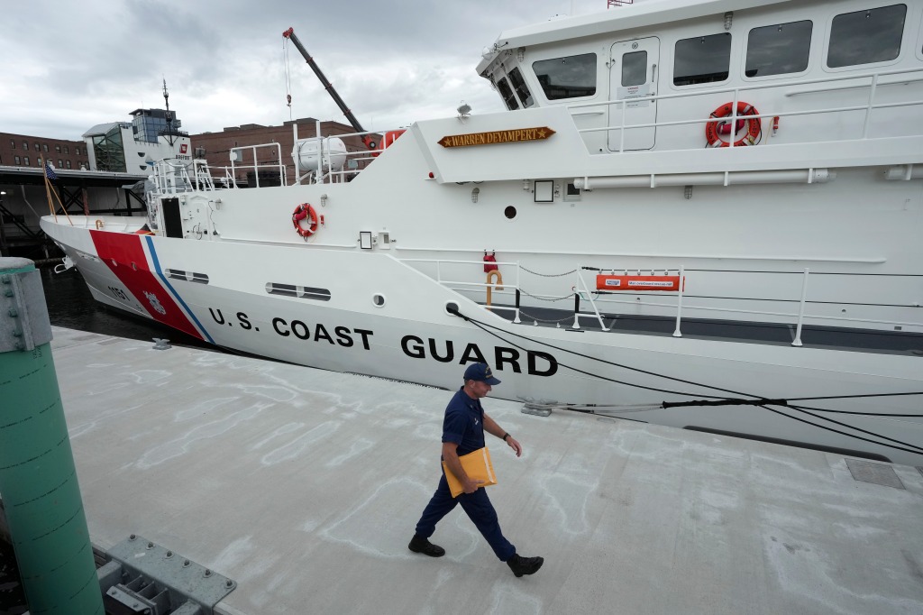 The U.S. Coast Guard Cutter Warren Deyampert is docked as a member of the Coast Guard walks past, Tuesday, June 20, 2023, at Coast Guard Base Boston, in Boston. 