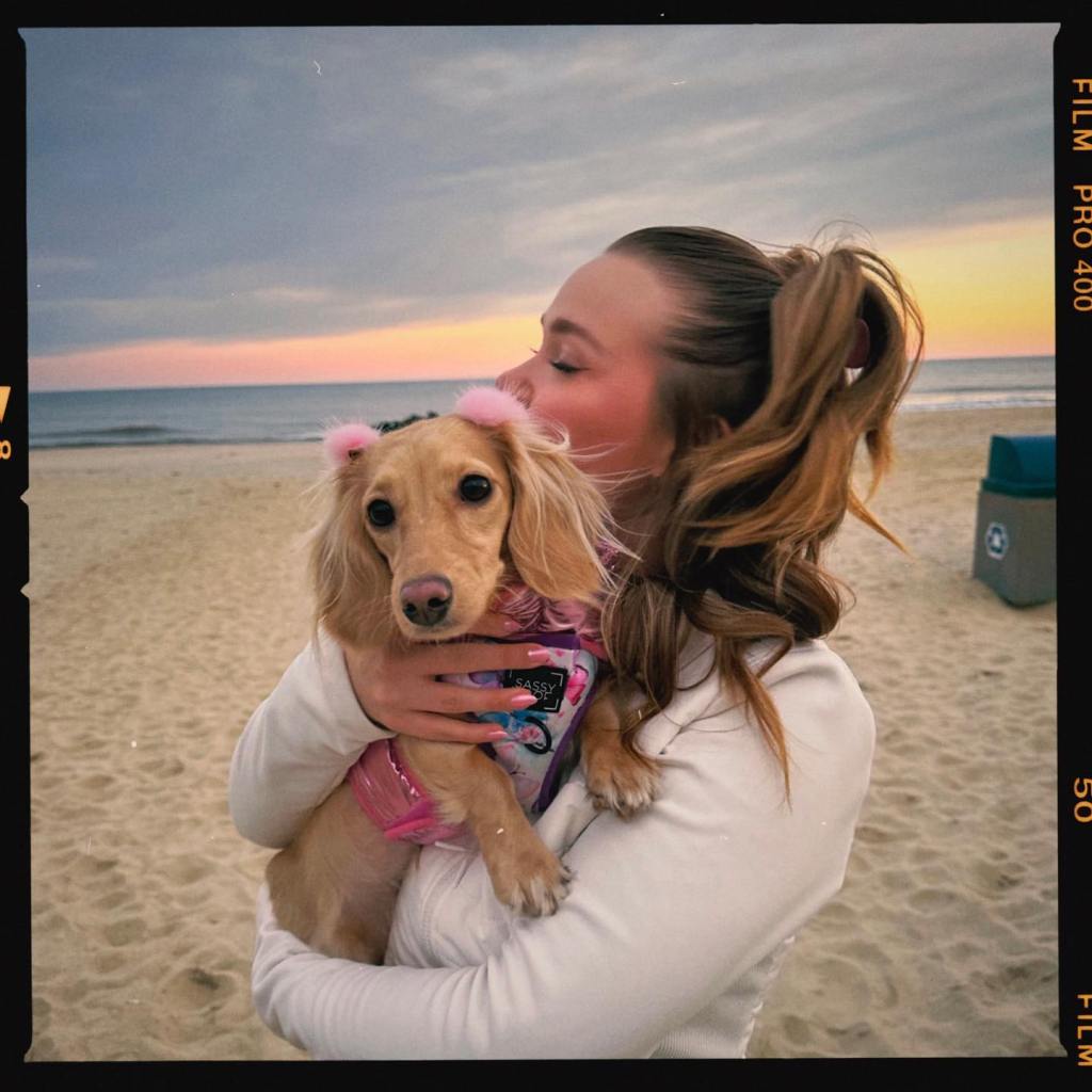 Alyssa McKay at the beach and holding her dachshund Ayla Rae