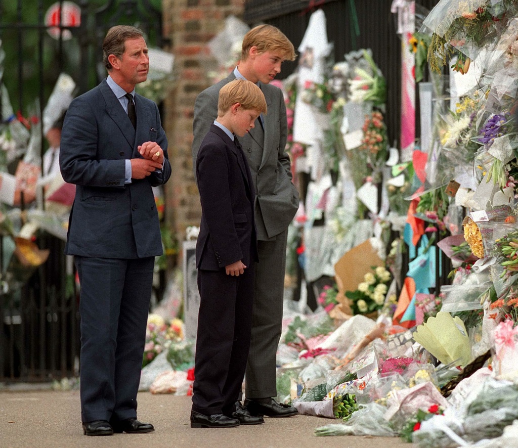 Prince William and Prince Harry look at floral tributes to Diana, Princess of Wales outside Kensington Palace on Sept. 5, 1997, in London.