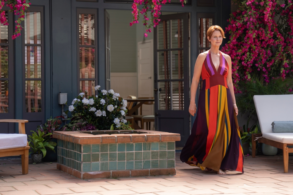 Miranda (Cynthia Nixon) smiles in a colorful dress. 