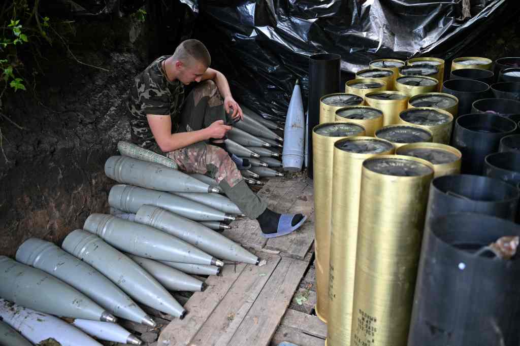  A Ukrainian artilleryman checks his mobile phone next to shells and the cases of propellant charges as he gets a rest at a position near Avdiivka in the Donetsk region on June 23, 2023, 