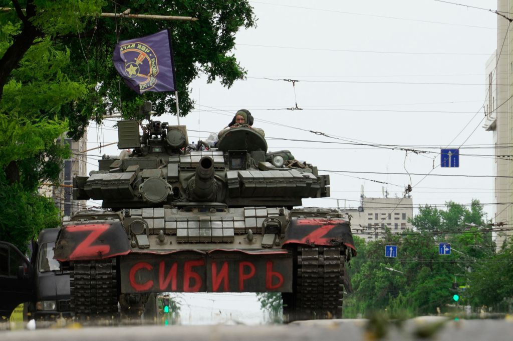 Members of Wagner group sit atop of a tank in a street in the city of Rostov-on-Don