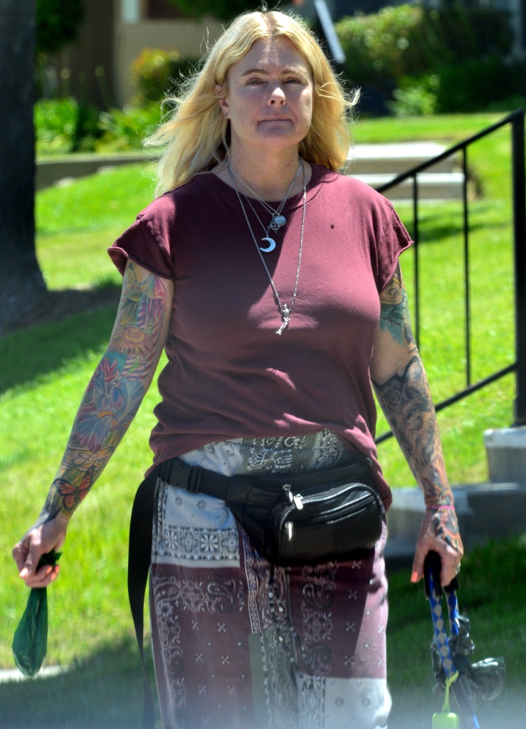 The 53-year-old swapped her iconic red swimsuit for sleeves of tattoos, showing off her impressive inkings as she took her pup for a stroll in the sunshine.