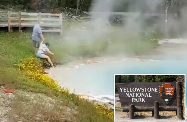 Yellowstone visitor dips hand in hot spring