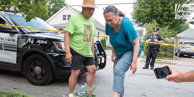 A couple leaves flowers outside of a Massachusetts house