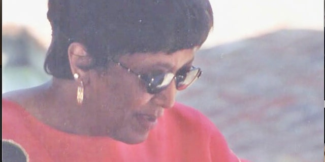 Minnie Smith wearing sunglasses and a coral blouse