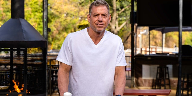 Troy Aikman holds a beer