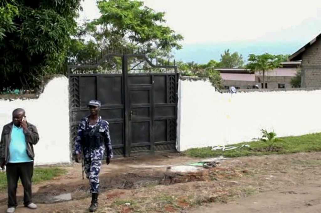 security forces are seen outside the gate of the Lhubiriha Secondary School following an attack on the school near the border with Congo, in Mpondwe, Uganda, Saturday, June 17, 2023