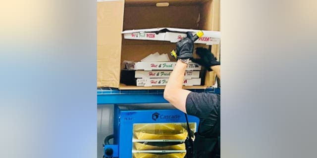 LAPD officer inspecting pizza box