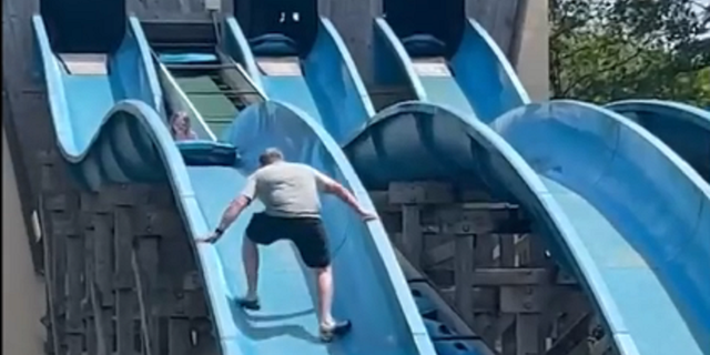 Father climbs water slide to get to daughter who is stuck