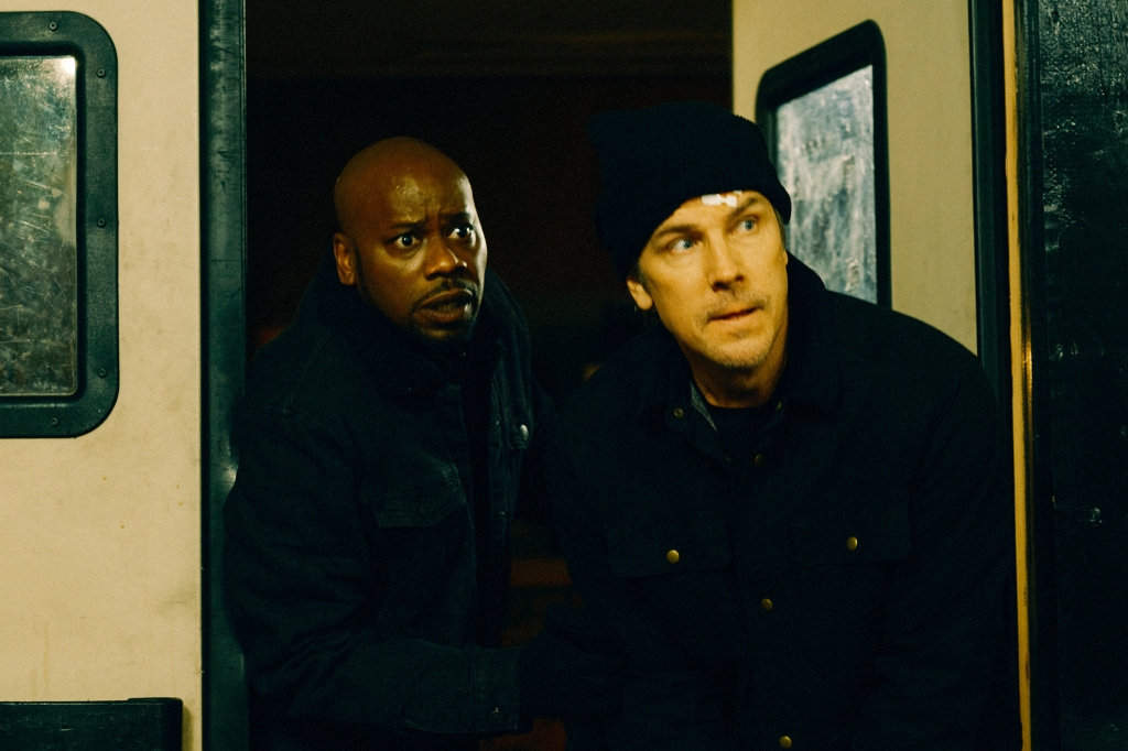 Malcolm Barrett and Michael Trucco as Leon and Touch in a scene from "Average Joe." They're coming through a swinging door; Leon looks panicked and Touch, who's wearing a black ski cap, looks determined. He's got a bandage on his head.