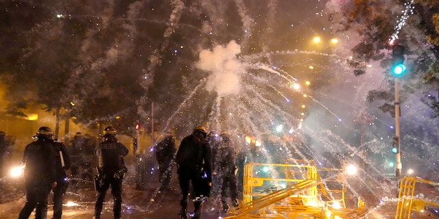 French police fire tear gas back at protesters who are launching fireworks at them in Nanterre, outside of Paris