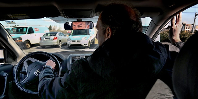 Former postal worker Gerald Groff demonstrates how postal service workers drive their trucks