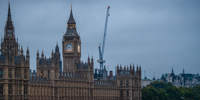 Photo shows the The Houses of Parliament in front of dark sky