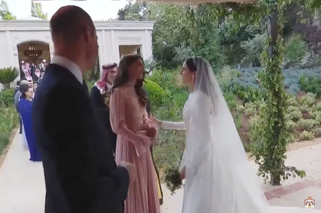 Prince William can be seen standing of to the side awaiting for his wife to end her conversation with now-Princess of Jordan, Rajwa Al Saif. 