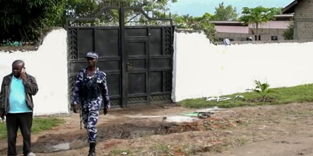 Ugandan security forces are seen outside the gate of the Lhubiriha Secondary School