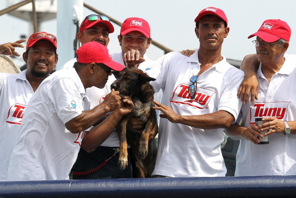 Bella the dog, surrounded by crew members of the "Maria Delia" after arriving back to port in Mexico.
