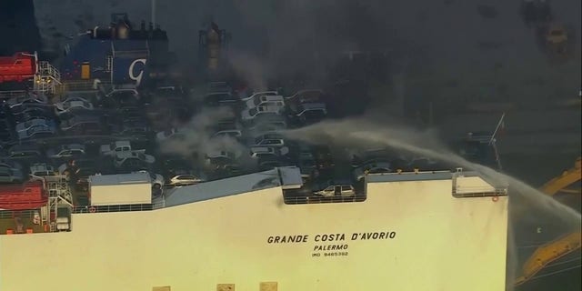 cars on deck of cargo ship with smoke