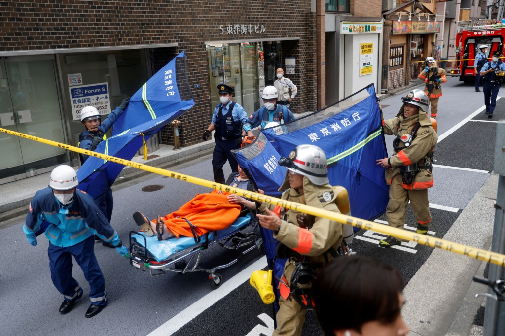 An injured person is transported from the site of an apparent explosion near Shimbashi station in Tokyo, Japan on July 3, 2023. 