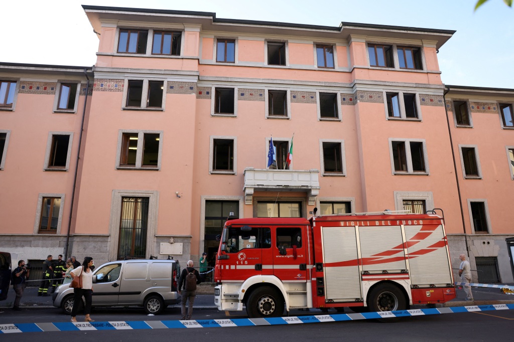 A firefighter truck and a police car are parked outside the "Casa per Coniugi" nursing home where the deadly fire broke out in Milan, Italy, on July 7, 2023.