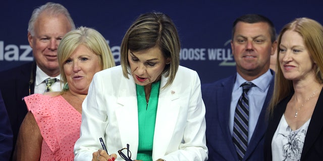 Iowa Governor Kim Reynolds signing