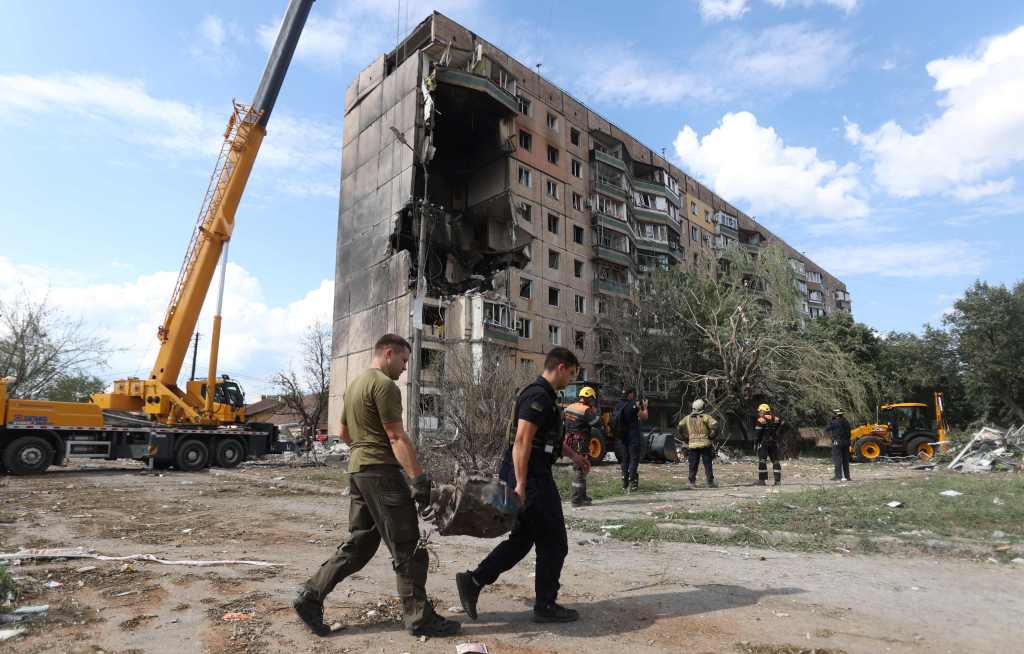  Rescuers carry a fragment of missile outside a nine-storey residential building partially destroyed as a result of Russian missiles strike in Kryvyi Rig.