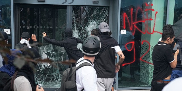 Young people vandalize window during French riots