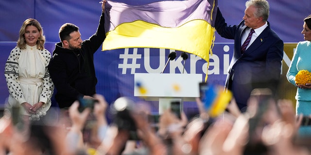 Zelenskyy holding a Ukraine flag