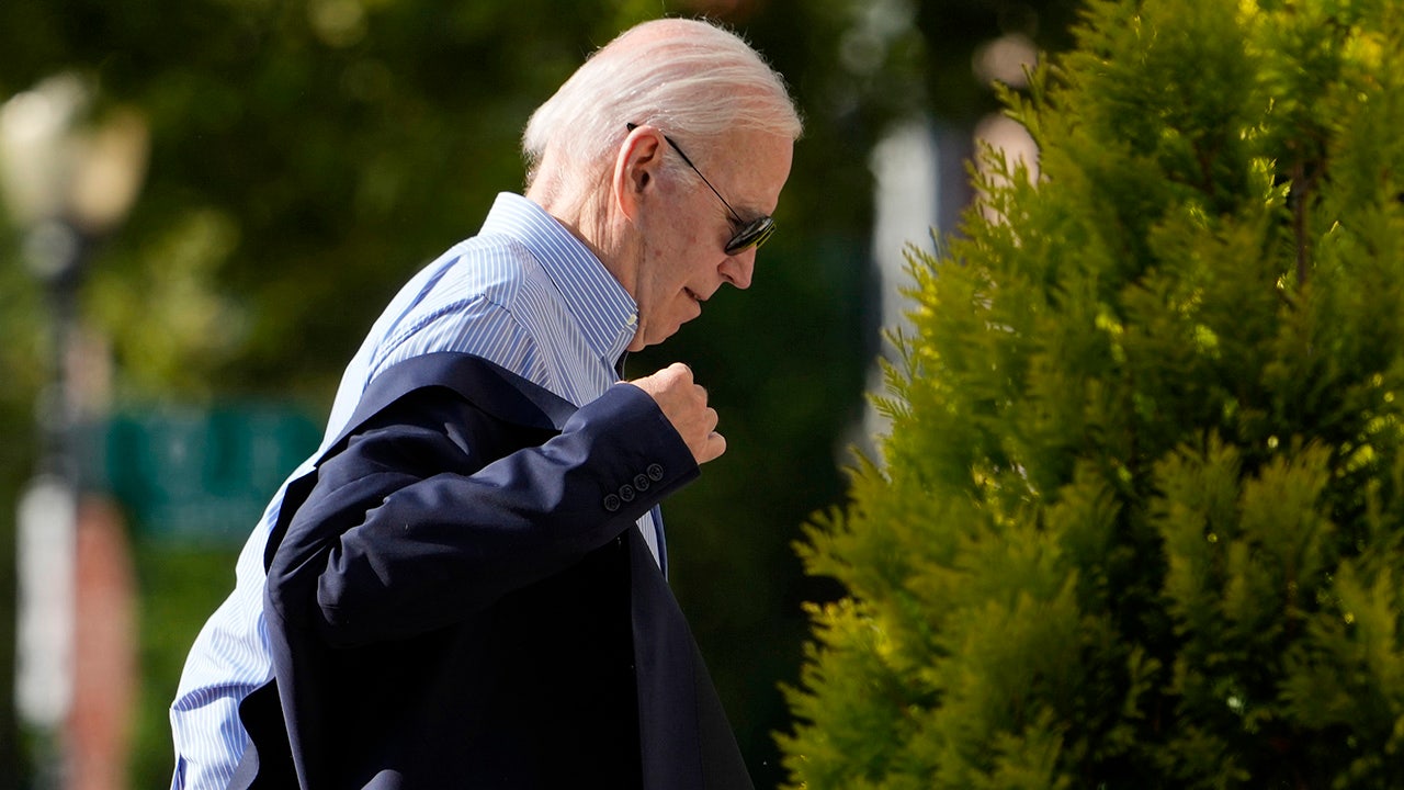 Joe Biden puts his jacket on while walking into church Sunday