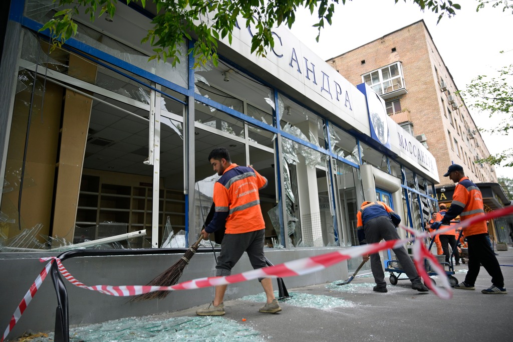 Workers sweep up broken glass at a damaged building after a reported drone attack in Moscow, Russia, on July 24, 2023. 