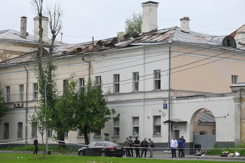 Investigators examine an area next to a damaged building after a reported drone attack in Moscow, Russia, on July 24, 2023. 