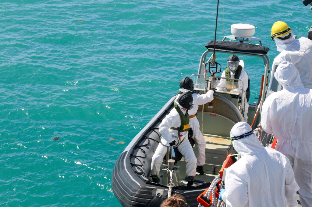 sailors from HMAS Brisbane prepare to board a rigid-Hulled inflatable boat to conduct search and rescue operations in the vicinity of Lindeman Island, Australia on Saturday, July 29, 2023, as part of a multi-national and multi-agency search and rescue effort following an Australian Army MRH-90 Taipan helicopter ditching in waters near the island.