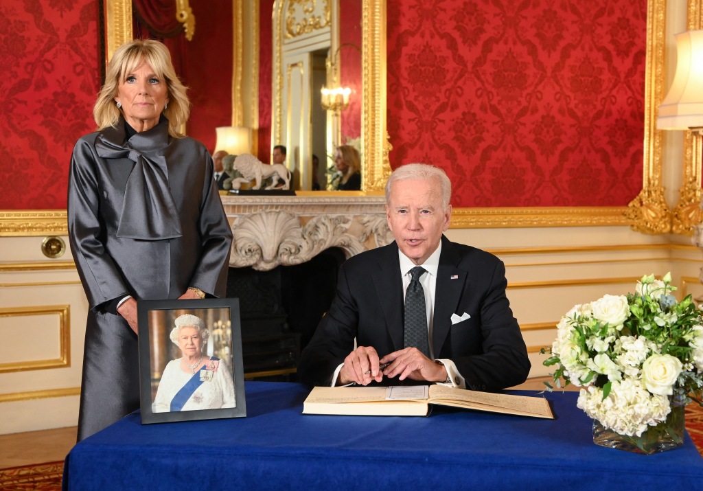 Biden (R), accompanied by the First Lady Jill Biden (L), sign a book of condolence at Lancaster House in London on September 18, 2022 following the death of Queen Elizabeth II on September 8, 2022.