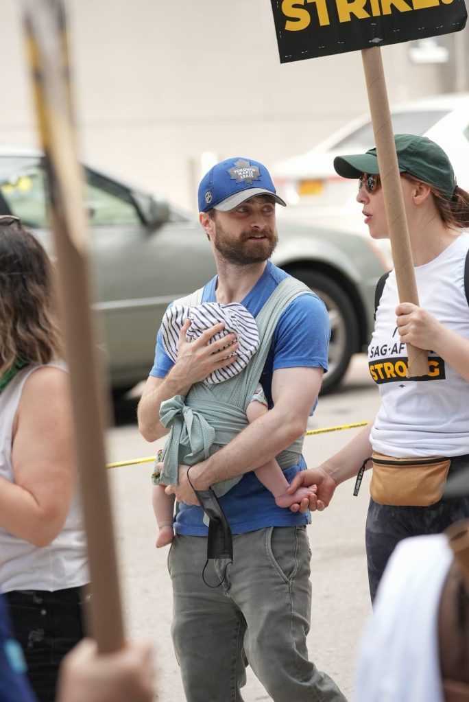 The "Harry Potter" actor, 33, was seen cradling his 4-month-old son.