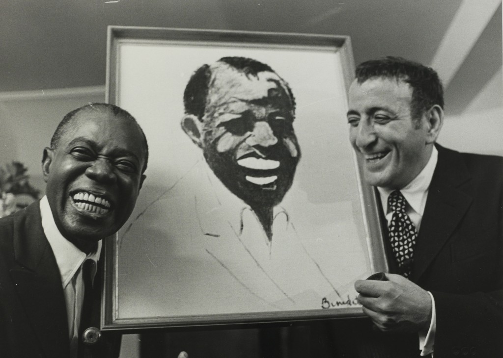 jazz musician Louis "Satchmo" Armstrong pictured in London being presented with a portrait of himself which was drawn by American entertainer, singer Tony Bennett,