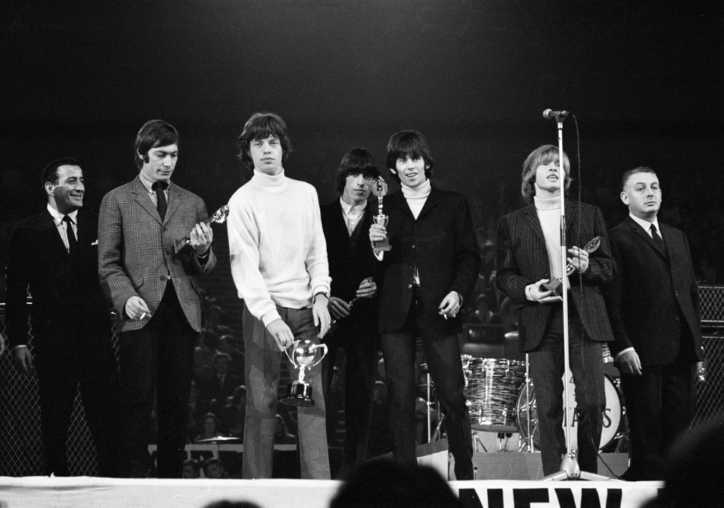 New Musical Express Poll Winners pop concert at Empire Pool Wembley, 1965. The Rolling Stones performing on stage during the concert. Left to right: Brian Jones, singer Mick Jagger, drummer Charlie Watts (mostly hidden) and Keith Richards. The Stones won awards for Best British R & B Group as well as Best New Disc Of The Year for their single (I Can't Get No) Satisfaction. Pictured here is the band with their awards, 11th April 1965. 