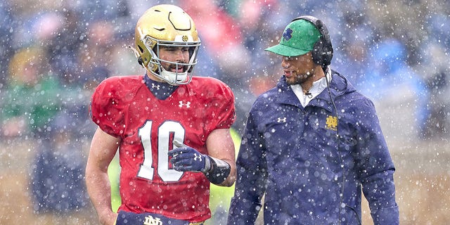 Sam Hartman talks with head coach Marcus Freeman