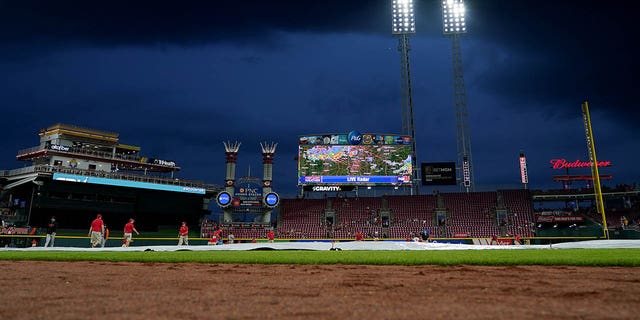 Grounds crew pulls the tarp onto the field