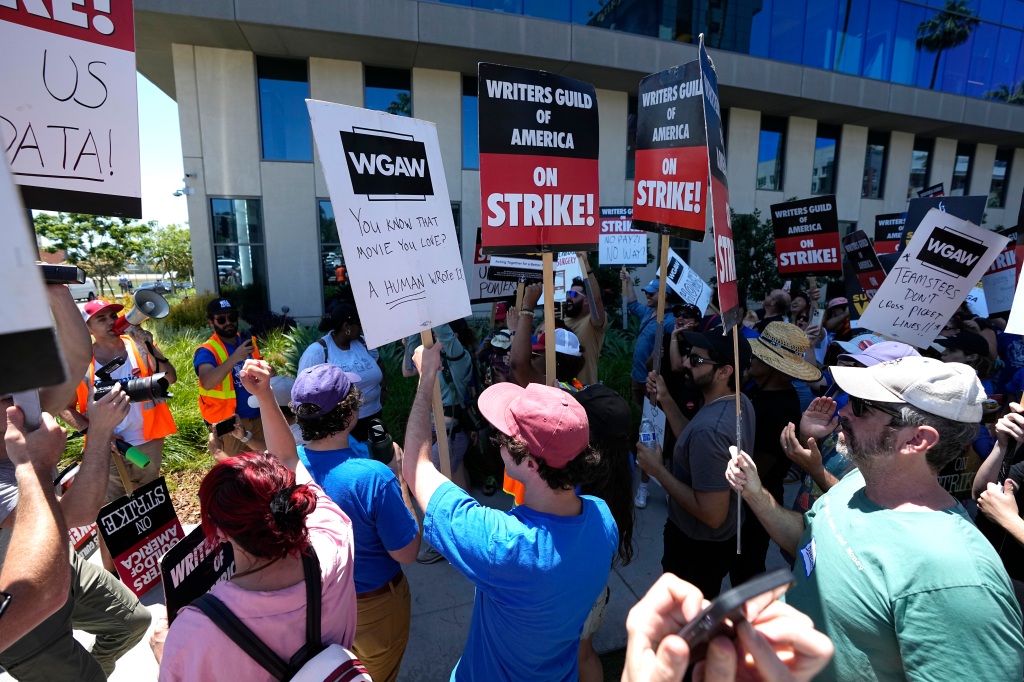 Picketers celebrate outside Netflix during a Writers Guild rally as a strike by The Screen Actors Guild-American Federation of Television and Radio Artists is announced on Thursday, July 13, 2023, in Los Angeles.