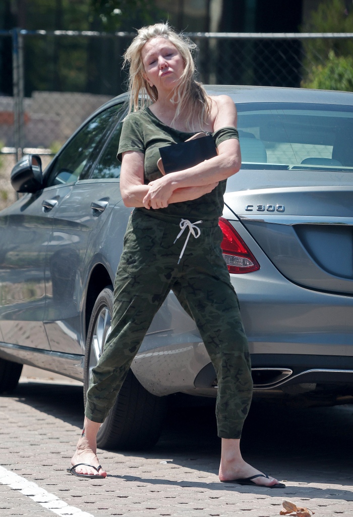 Heather Locklear sparks major fears for her personal safety as she is seen precariously balancing herself along the edge of a tall office building whilst appearing to be in some sort of distress.