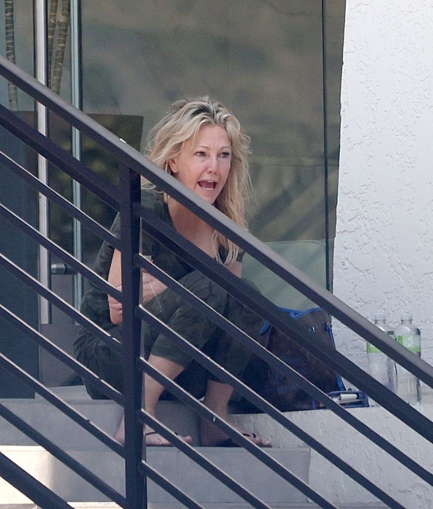 Heather Locklear sparks major fears for her personal safety as she is seen precariously balancing herself along the edge of a tall office building whilst appearing to be in some sort of distress.