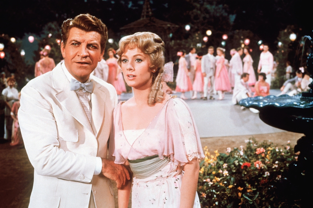 Robert Preston and Shirley Jones in "The Music Man." They're both dressed in white (suit for him, dress for her); he's holding her arm and they're looking at something off-camera.