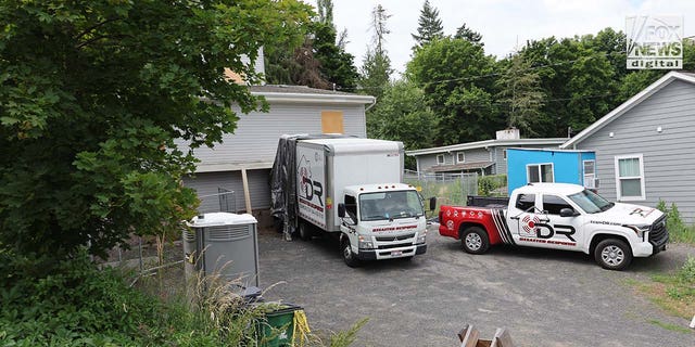 Trucks labeled Disaster Recovery parked as workers went in and out of the King Road home in Moscow idaho