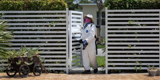 A Miami-Dade Mosquito Control inspector sprays a pesticide to kill mosquitos