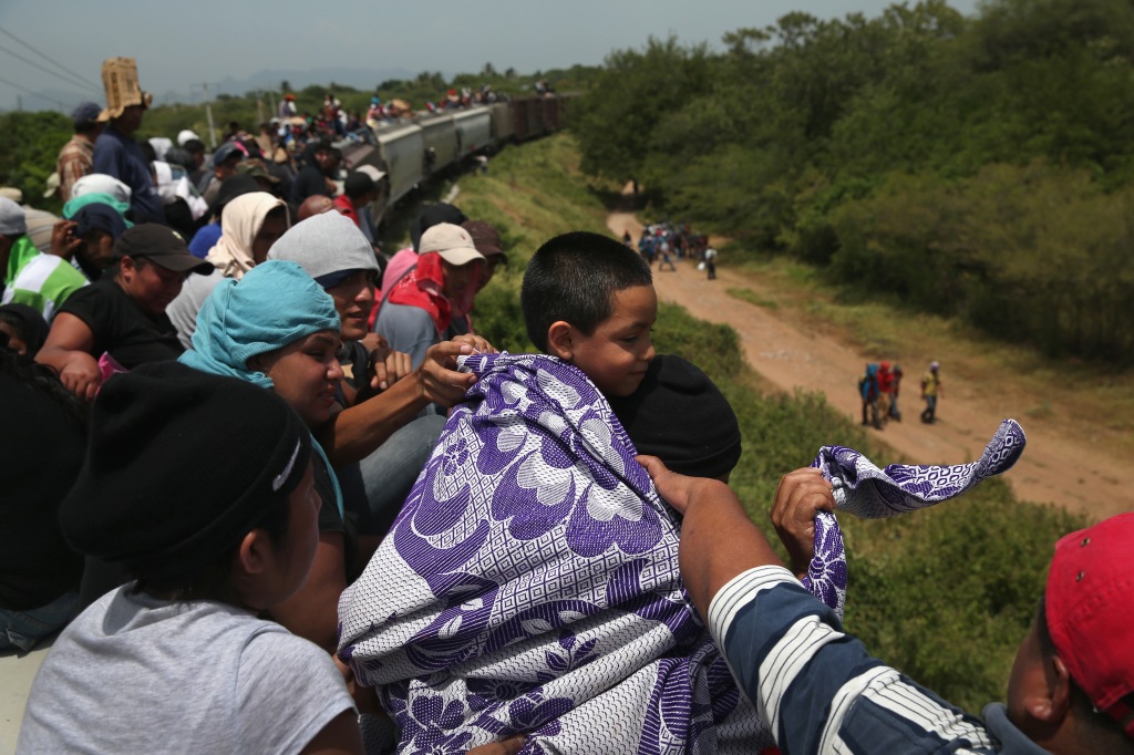 Migrants from Central America cross into Mexico on a train.