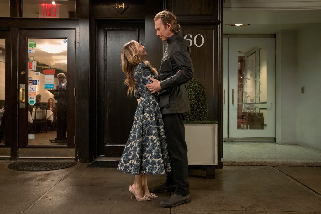 Aidan and Carrie embrace in the street.