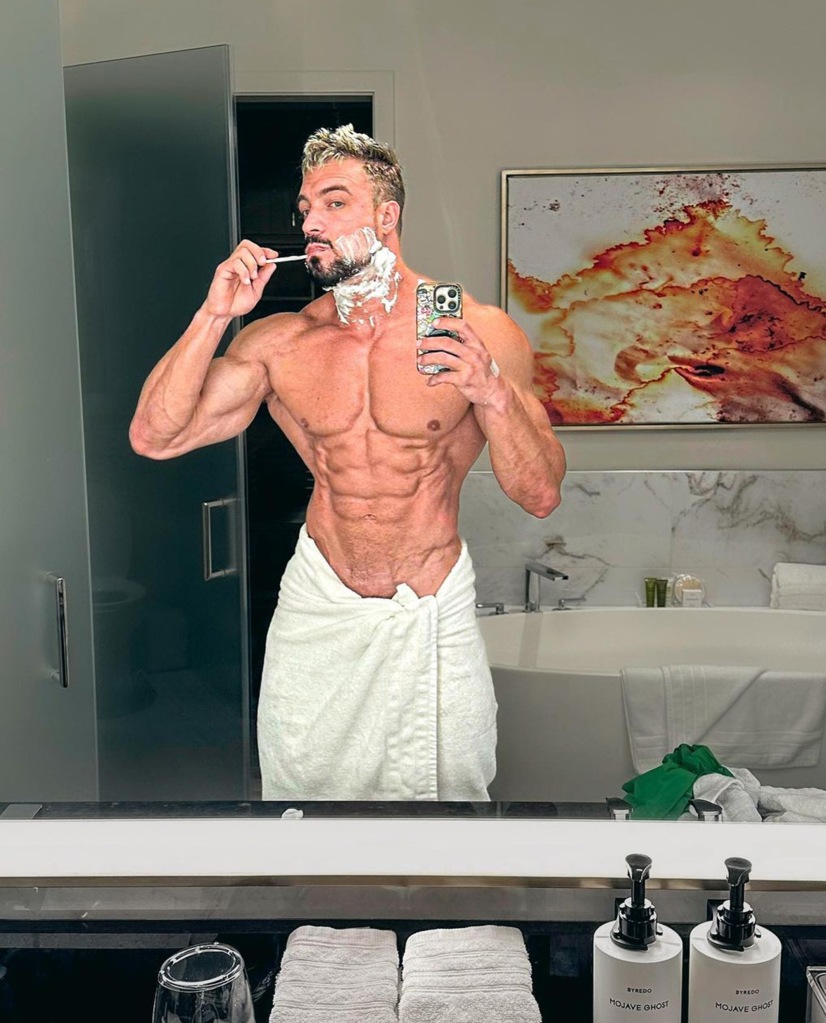 Shirtless Jo Lindner in towel brushing teeth
