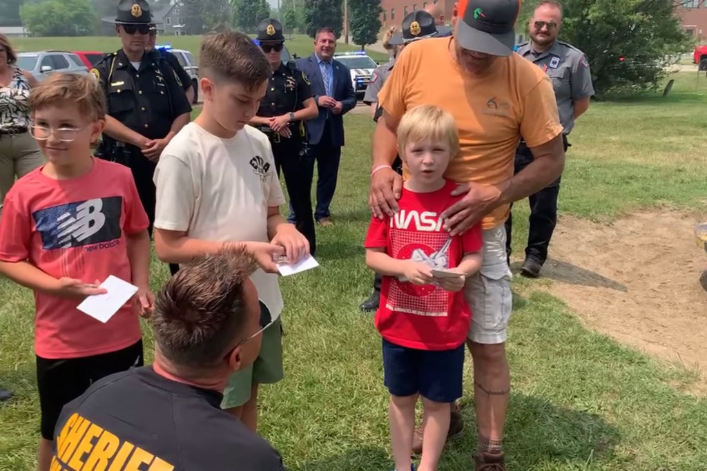 Griffin speaks to the camera as his grandfather stands behind him. 