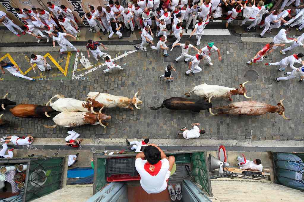 A Pamplona resident watching bulls run down a street.